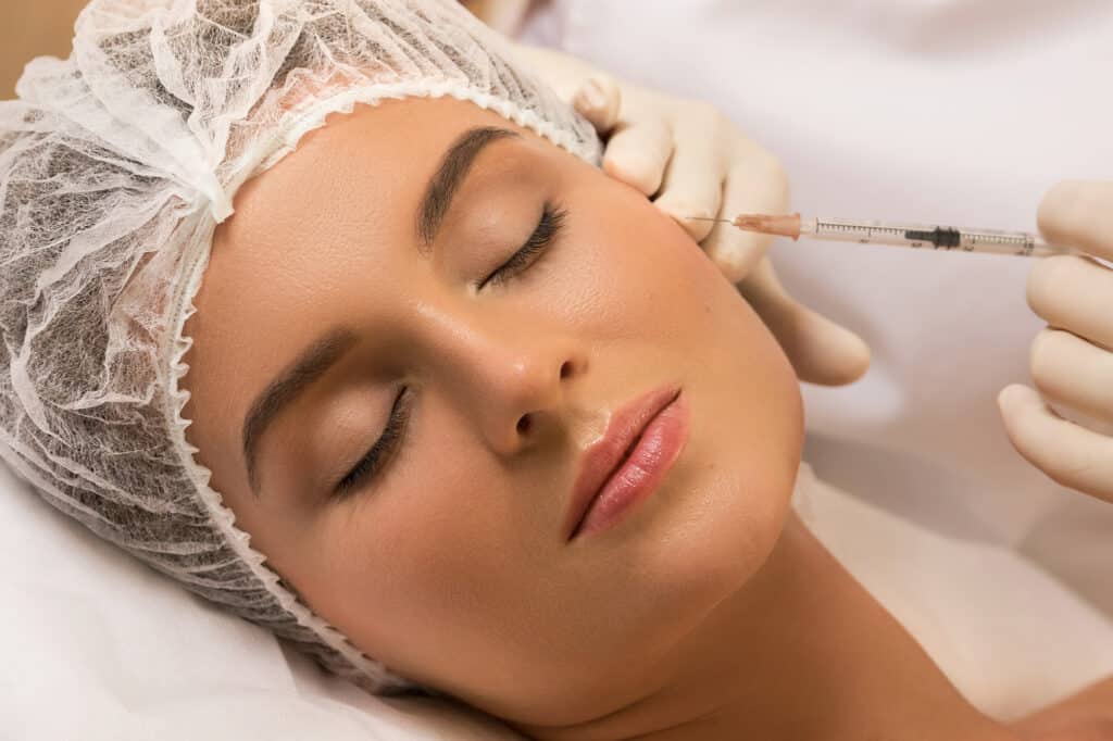 Woman in professional beauty salon during facial injections for rejuvenation